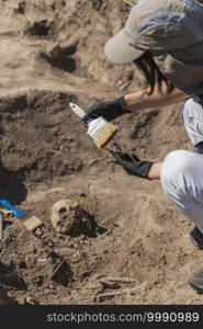 Anthropology Field Work. Anthropologists holding ancient human bones at ancient burial site. . Anthropology. Anthropologist holding ancient human bones recovered from burial site.