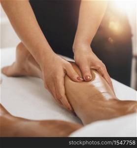 Anti cellulite massage. Masseuse massaging a calf area of a female leg to reduce cellulite . Anti Cellulite Massage. Masseuse Massaging a Female Calf
