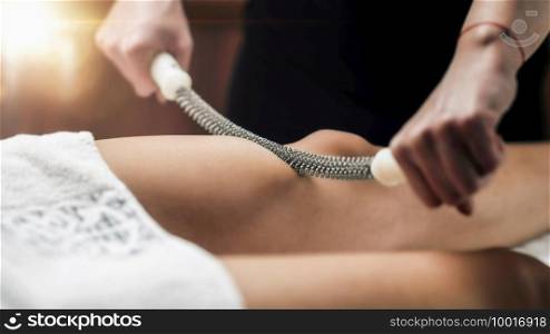 Anti-cellulite thigh massage with a metal rolling pin