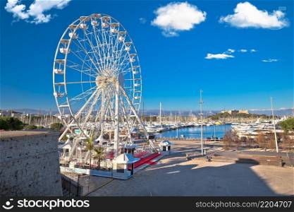 Antibes, France. Giant ferris wheel and yachting harbor view in town of Antibes, French riviera, Southern France