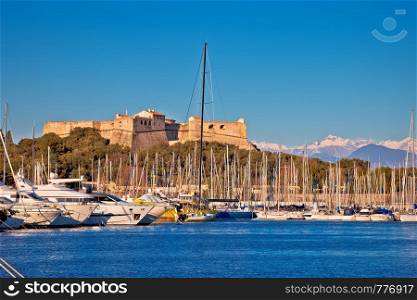 Antibes harbor and old fortress with Alps snow peaks background view, Southern France