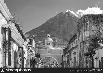 Antigua Guatemala, classic colonial town with famous Arco de Santa Catalina and Volcan de Agua behind in stunning black and white