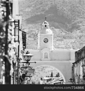 Antigua Guatemala, classic colonial town with famous Arco de Santa Catalina and Volcan de Agua behind in stunning black and white