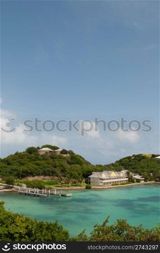 Antigua Long Bay, gorgeous seascape view surrounded by tropical nature and some typical houses