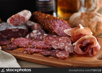 Antipasti dish with bacon, jerky, salami, crispy grissini with cheese. A meat appetizer is a great idea for a beer.