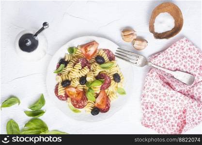 Antipasto salad with pasta, tomato, olives, red onion, bell pepper, salami