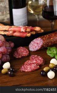 Antipasto. Sun-dried ham, salami, crispy grissini with grapes. A meat appetizer is a great idea for wine.