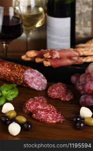 Antipasto. Sun-dried ham, salami, crispy grissini with grapes. A meat appetizer is a great idea for wine.