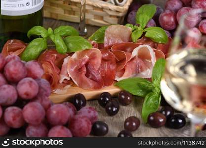 Antipasto. Wine set snack sun-dried ham jamon with grapes and olives