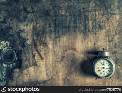 Antique alarm clock on rustic wooden background. Vintage style toned picture