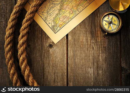 Antique brass compass and rope over old map