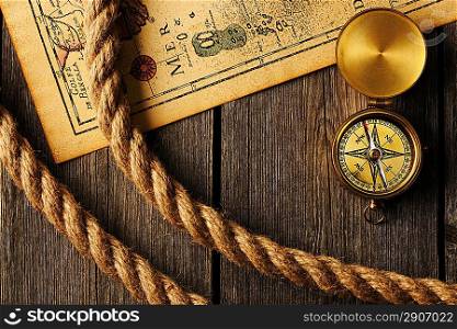 Antique brass compass and rope over old map