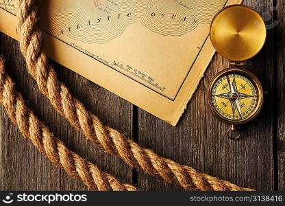 Antique brass compass and rope over old map