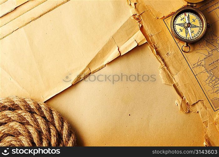 Antique brass compass and rope over old map
