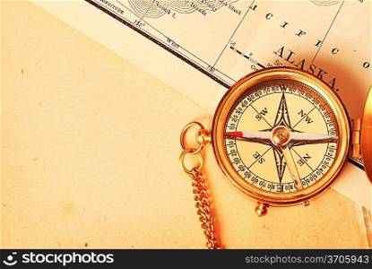 Antique brass compass over old Alaska map