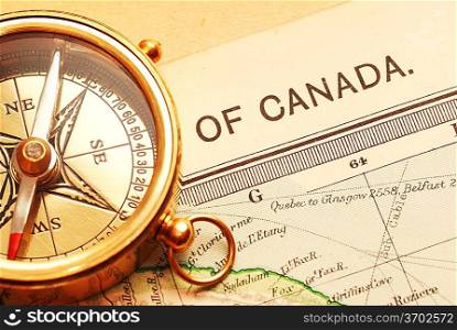 Antique brass compass over old Canadian map background