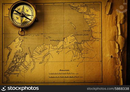 Antique brass compass over old map