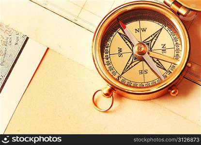 Antique brass compass over old map background