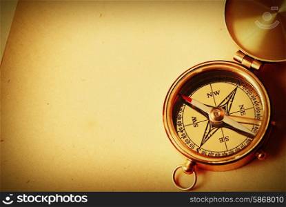 Antique brass compass over old map background