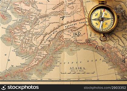 Antique brass compass over old XIX century map