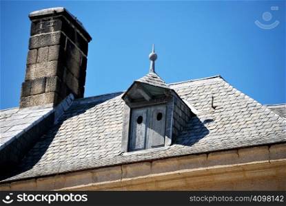 Antique chimney and a closed window on the roof