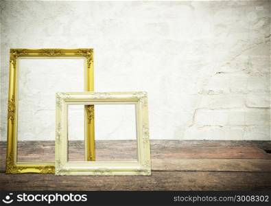 Antique classical frame on wooden table with concrete texture on background.