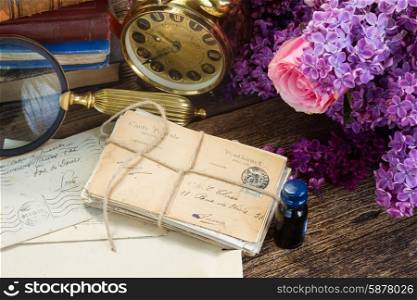 antique clock with pile of mail. antique alarm clock with pile of mail and flowers