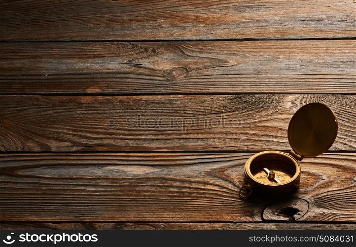 Antique compass over wooden background. Antique brass compass over wooden background
