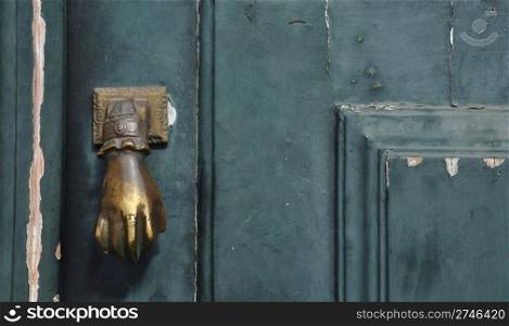 antique door handle on a green peeling background