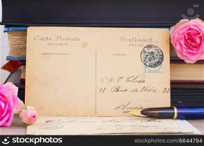 antique empty postcard with flowers and quill pen on table