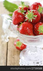 Antique glass filled with fresh tasty strawberries and vintage lace