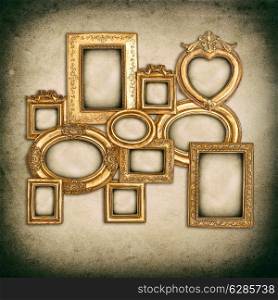 antique golden frames over grungy wall background. empty baroque framework with canvas for photo and picture