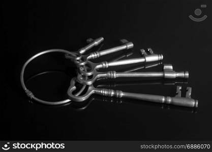 Antique keys on a keyring on black background