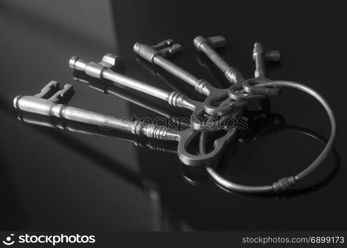 Antique keys on a keyring on black background