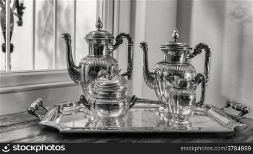 antique silver tea set with a two teapots, milk jug, sugar bowl, and a tray