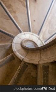antique spiral ladder from marble stone in day light