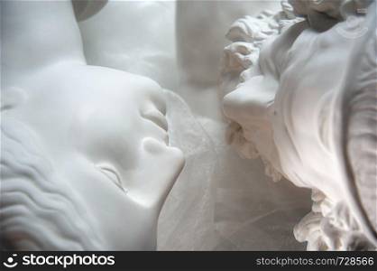 Antique statues of woman and man heads closeup. Concept of style, vintage, love. Toned.. Antique statues of woman and man heads close up. Concept of style, vintage, love.