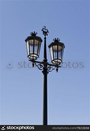 Antique street lamp against a blue sky