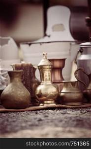 Antique teapots and cups on a flea market, outdoors