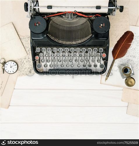 Antique typewriter and vintage office tools on wooden table. Flat lay still life. Reto style toned picture