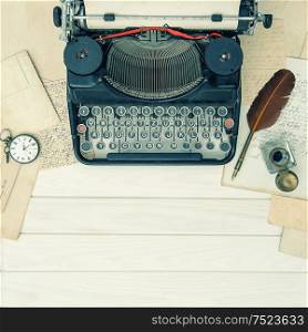 Antique typewriter and vintage office tools on wooden table. Vintage toned background