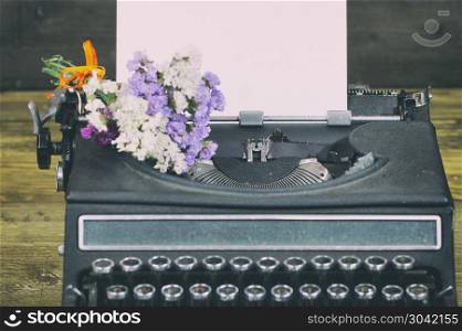 Antique typewriter. Old typewriter with paper and dried flowers
