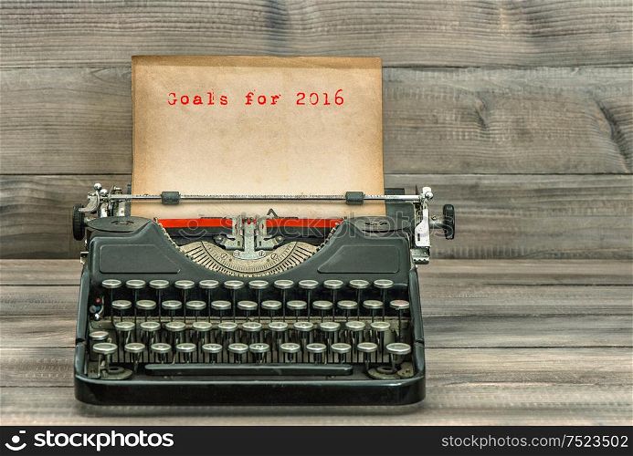 Antique typewriter with grungy paper on wooden background. Goals for 2016. Business concept. Selective focus