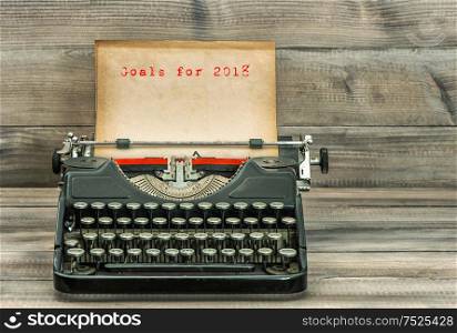 Antique typewriter with grungy paper on wooden background. Goals for 2018. Business concept. Selective focus