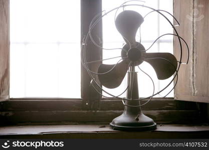 Antique vintage air fan in the window backlight