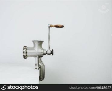 Antique, vintage meat grinder on a white wooden table. Antique, vintage meat grinder