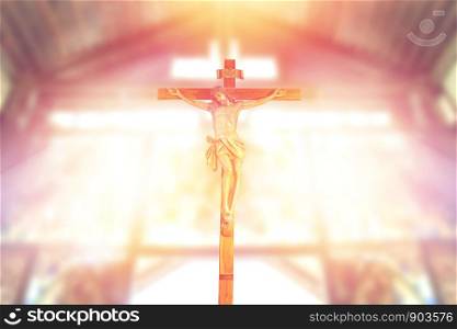 antique wooden crucifix, jesus on the cross in church with ray of light from stained glass, image of the crucifixion