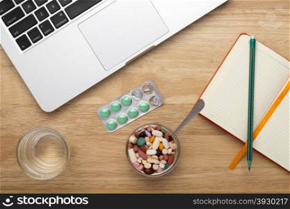 Antivirus set with green pills blister pack and laptop. Antivirus set with green pills blister pack and laptop on wooden table