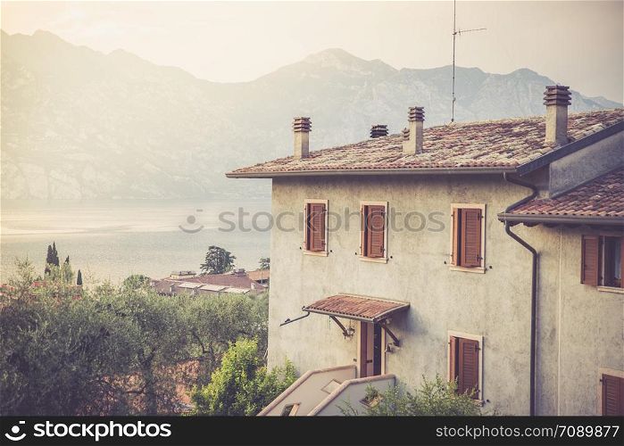 Apartment house, mountains and colourful sky. Italy.