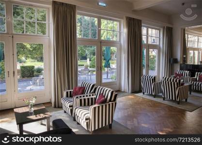 Apeldoorn,Holland,14-spet-2019: exclusive interior of the dining room from a hotel with paintings on the wall and windows to the garden. exclusive interior of the dining room from a hotel